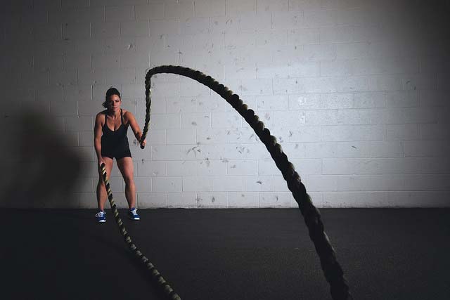 A woman doing a battle ropes exercise
